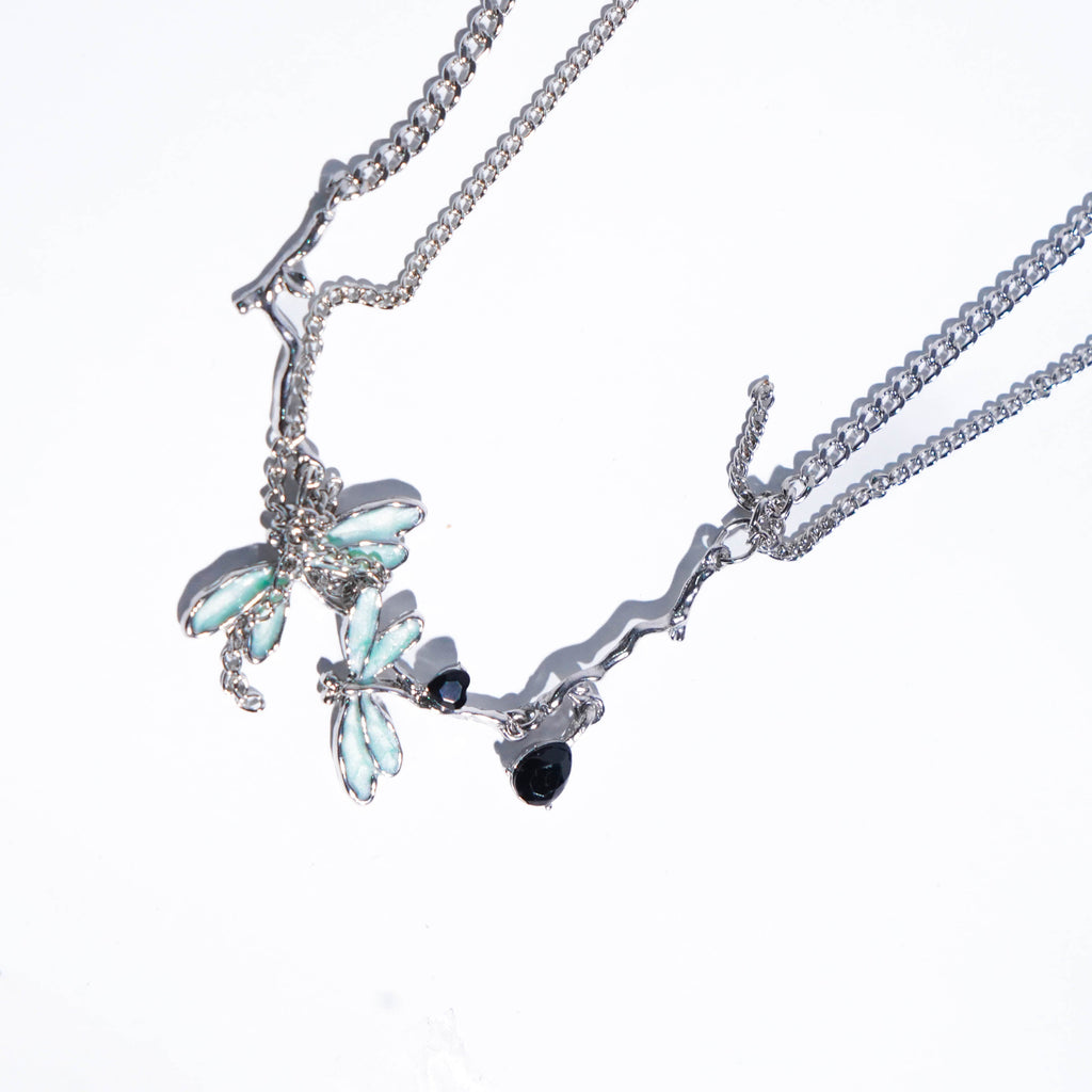 Two silver necklaces with gemstones on a white background